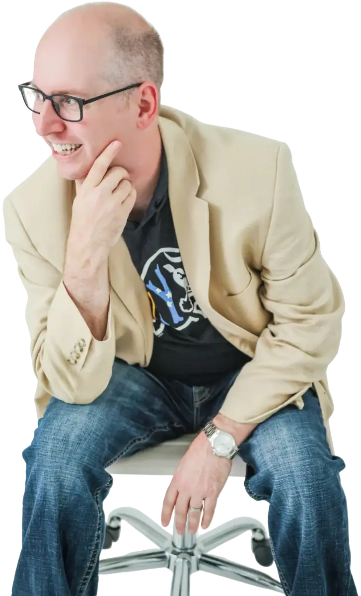 Jeremy Simpson of Bull City Web Design in a tan blazer over a Bull City shirt, seated with hand on chin